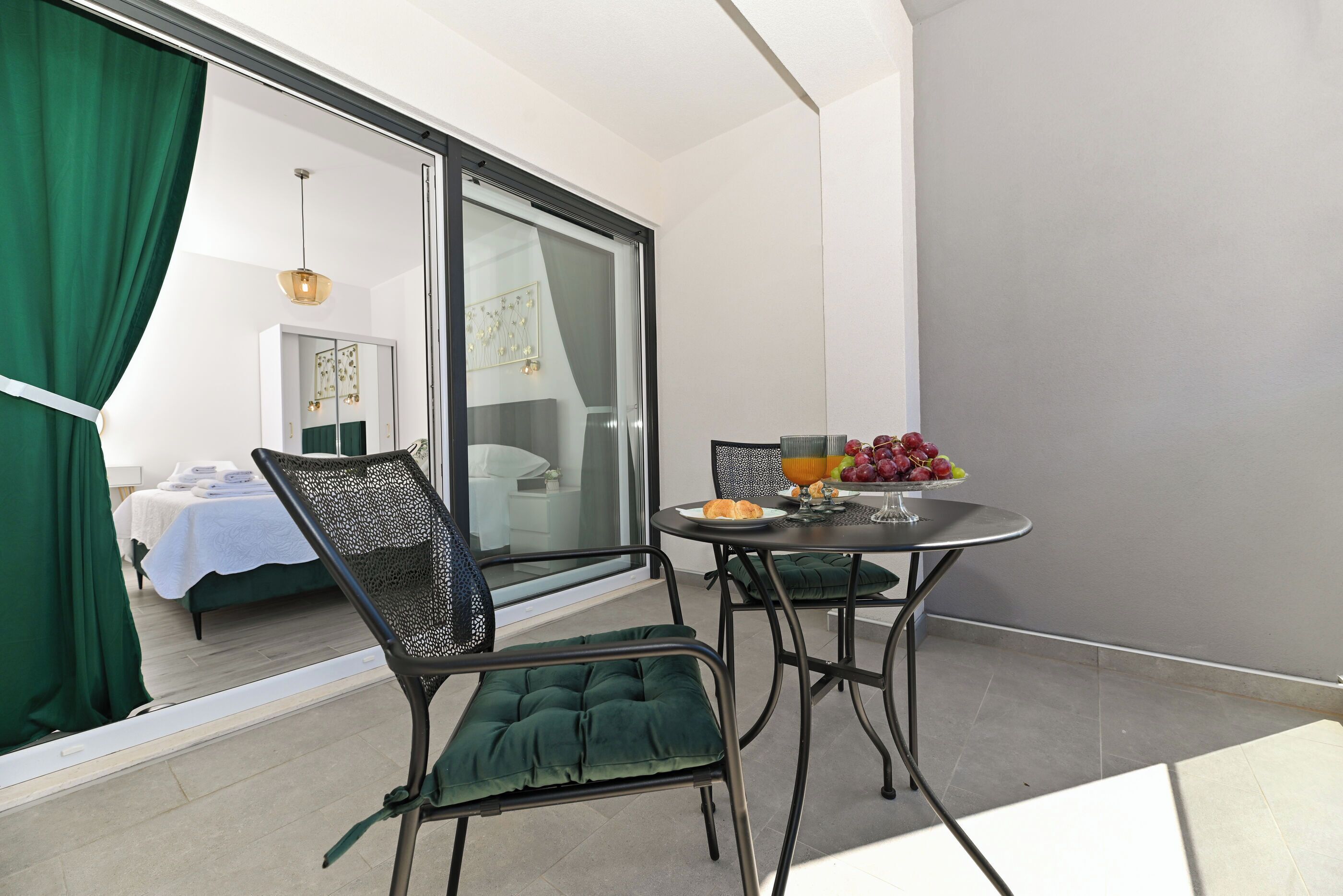 Un balcón con una mesa de comedor, sillas y un frutero.