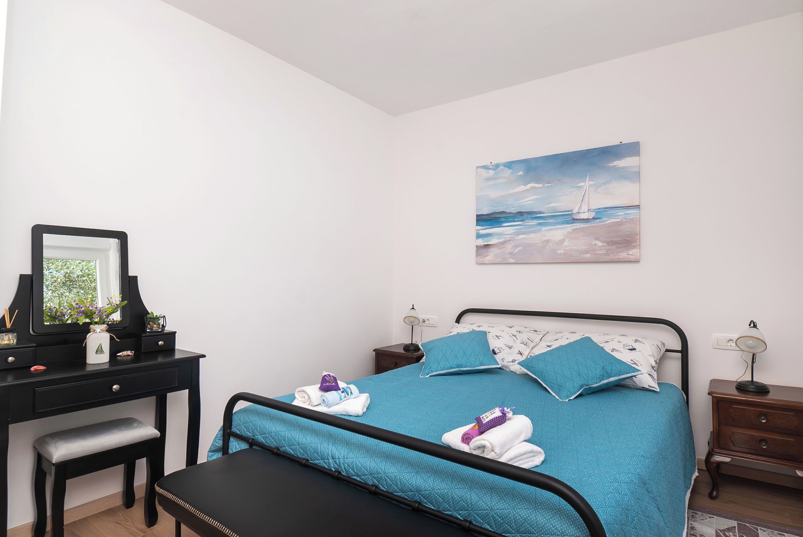 Une chambre à coucher avec un lit, un bureau, une chaise et une table de chevet.