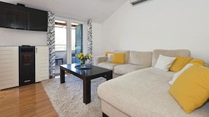 A modern living room with a sofa set, a coffee table, and a flat-screen TV. - Apartment Leo (Ploce)