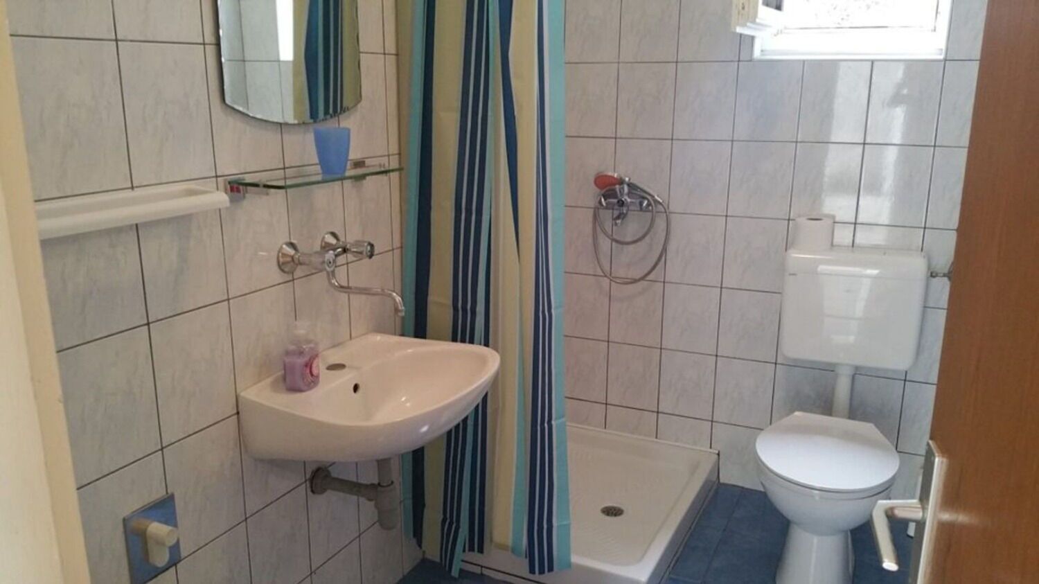 A bathroom with a white sink, a toilet, and a shower area.