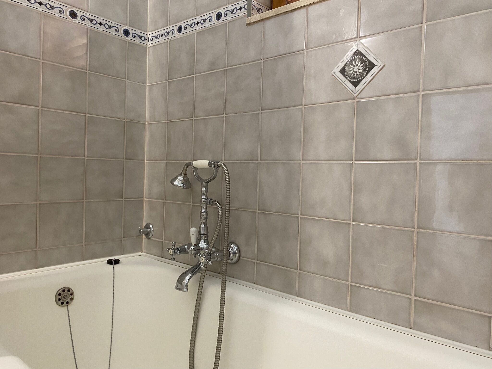 A bathroom with a bathtub, a shower, and a wall-mounted faucet.