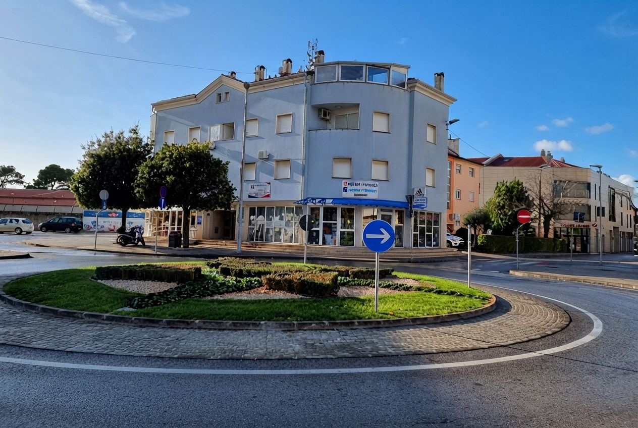 A multi-story building with a blue sign indicating a right turn.