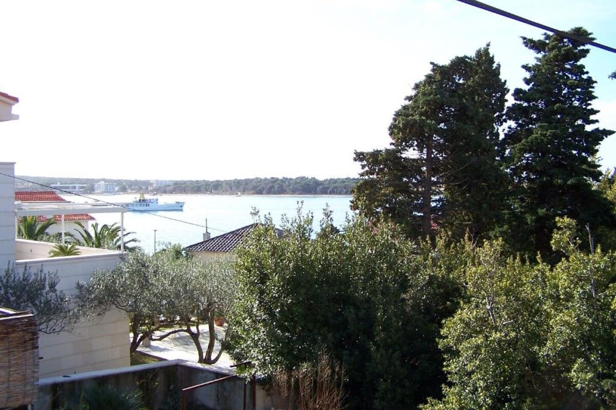 Ein Wohngebiet mit Blick auf ein Gewässer, ein Boot und üppige Vegetation.