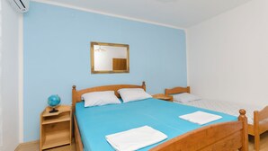 Una habitación con una cama grande, dos mesitas de noche, un tocador, un espejo y un globo terráqueo.