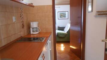 Apartamento (A3) | Cozinha privada | Geladeira, cooktop, talheres/pratos/utensílios de cozinha, freezer