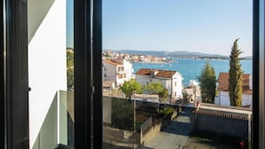 A balcony with a view of a coastal town and the sea. - Apartments Andrea (Sibenik)