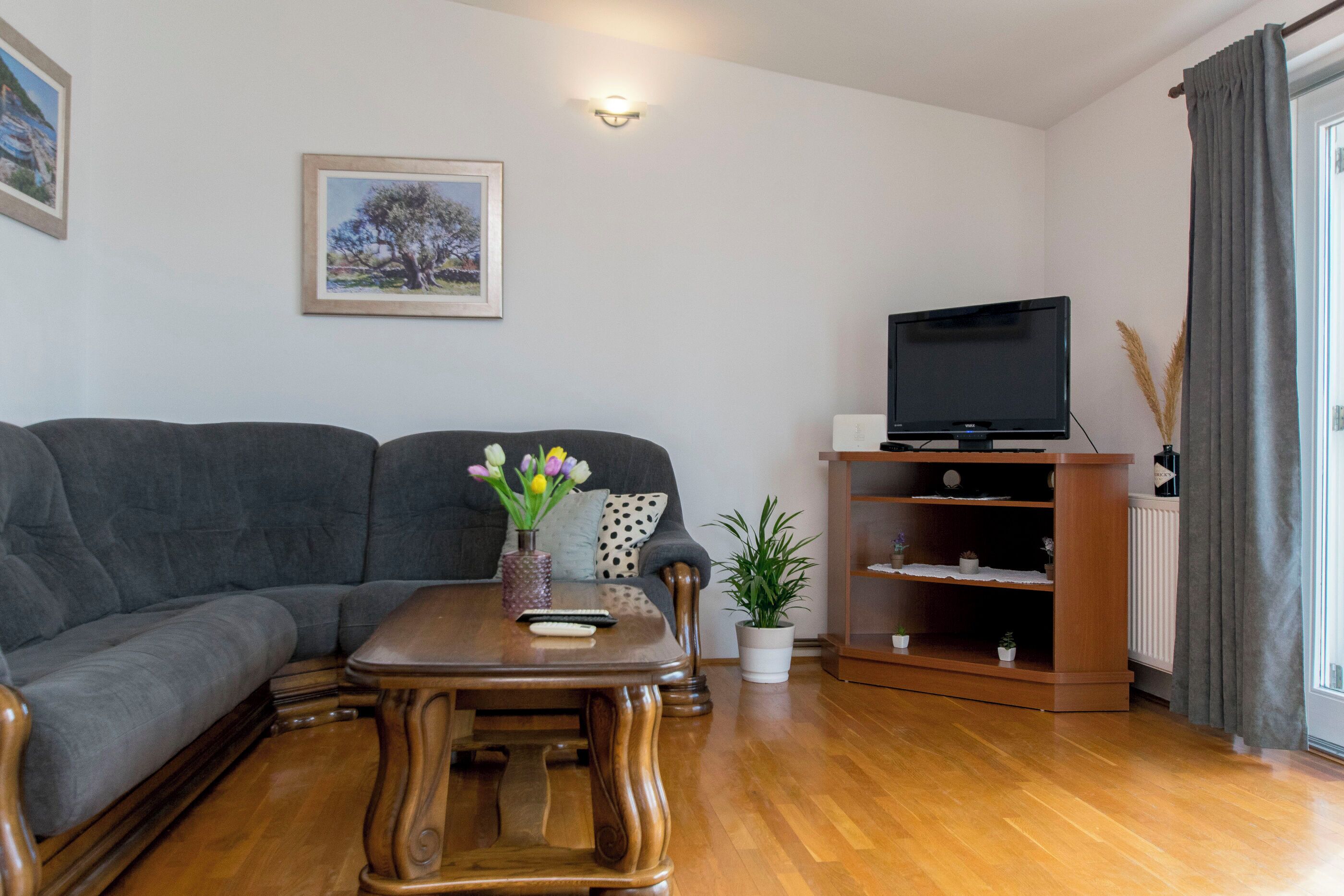 A living room with a sofa, a wooden coffee table, a TV, and a bookshelf.