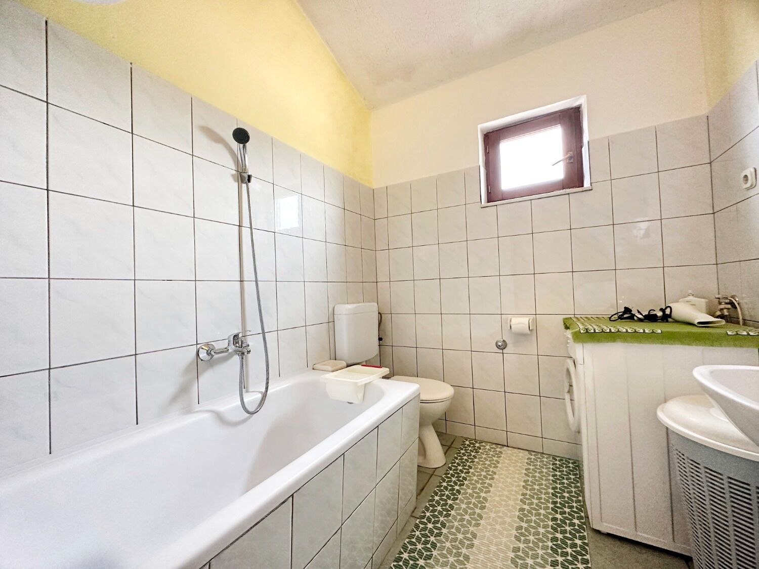 A bathroom with a bathtub, toilet, and sink.