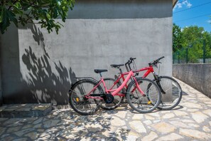 Una bicicleta estacionada junto a una pared con pavimento de piedra.
