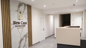 A reception area with a marble wall, a wooden panel, and a sign for 'New Casa Boutique Hotel'. - New Casa  (Yerevan)