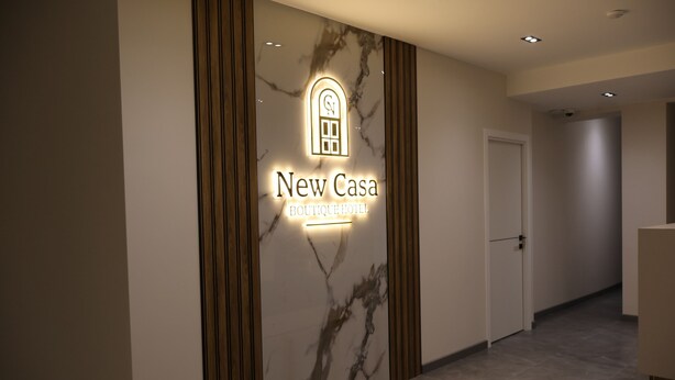 A hotel entrance with a marble wall and a sign reading "New Casa Boutique Hotel". - New Casa  (Yerevan)