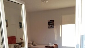 Ein Zimmer mit einem Bett, einem Schlafsofa und einem Spiegel.