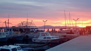 Een jachthaven met boten aan een steiger tijdens de zonsondergang.