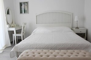 A bedroom with a bed, a bedside table, a lamp, a chair, and a desk with a mirror. - Apartments Adriona (Makarska)