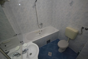 Une salle de bain avec une baignoire, des toilettes et un lavabo.