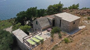 Una casa de piedra con un patio y vista al mar.
