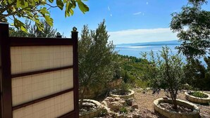 Un jardín con macetas de piedra y una pérgola de madera.