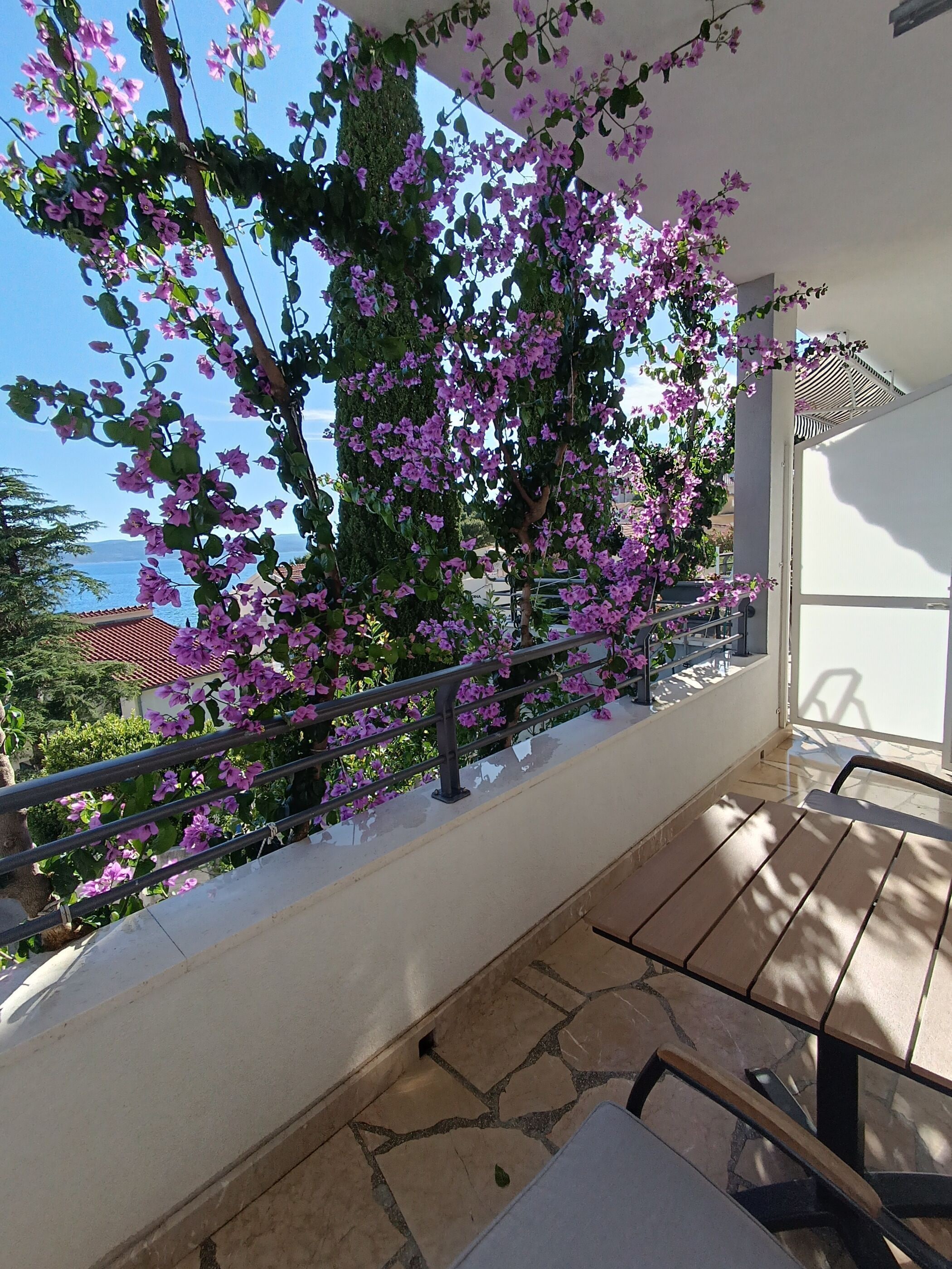 Ein Balkon mit Meerblick, einem Geländer und einem Tisch.