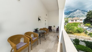 Un balcon doté de meubles en osier et offrant une vue sur une montagne.