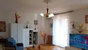 Ein Wohnzimmer mit einer Couch, einem Couchtisch, einem Fernseher und einem Schrank.