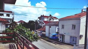 Una vista di una strada con edifici, un furgone blu e una ringhiera rossa.