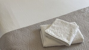 A neatly made bed with a quilted bedspread and two pillows.