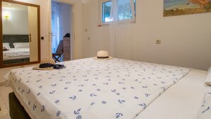 A bedroom with a bed, a mirror, a window with curtains, a painting, and a door leading to another room. - Apartment Kova (Stari Grad)