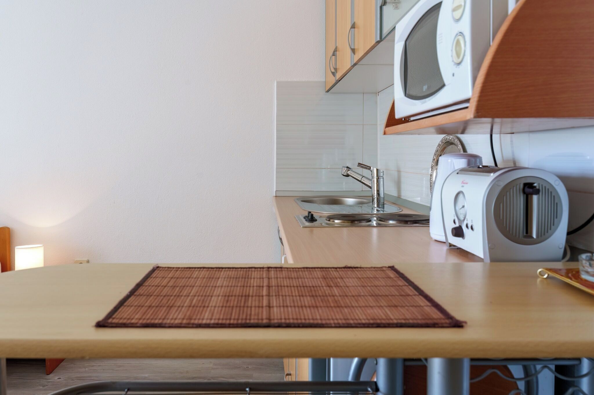 Une cuisine équipée d’un four à micro-ondes, d’un grille-pain et d’un évier.