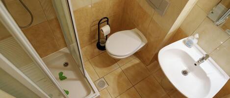 A bathroom with a shower, toilet, and sink.