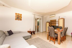 Ein modernes Schlafzimmer mit einem großen Bett, einem Esstisch mit Stühlen und einem kleinen Nachttisch.