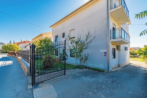 A two-story building with a gated entrance, a small garden, and a balcony. - Apartments Tomy (Medulin)