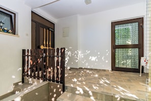 A staircase with a metal railing leading to a door with a wooden frame. - Apartments Tomy (Medulin)
