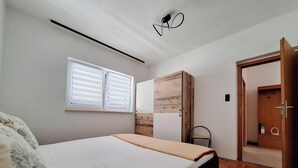 Una camera da letto con un letto, un armadio, una finestra e una porta.