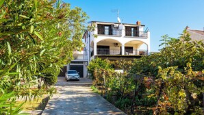 A two-story house with a driveway leading to the garage. - Apartments Brodarica Beach (Sibenik)