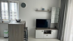 Eine moderne Küche mit einer Holztheke, einem Flachbildfernseher und einem Essbereich.