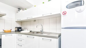 Una cocina moderna con armarios blancos, un lavamanos doble y un lavavajillas integrado.
