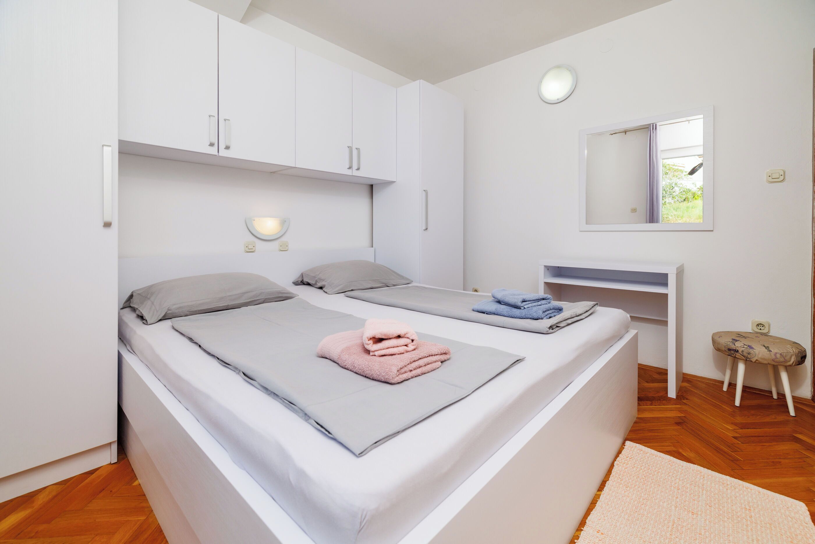 Un dormitorio con cama, mesita de noche y espejo.