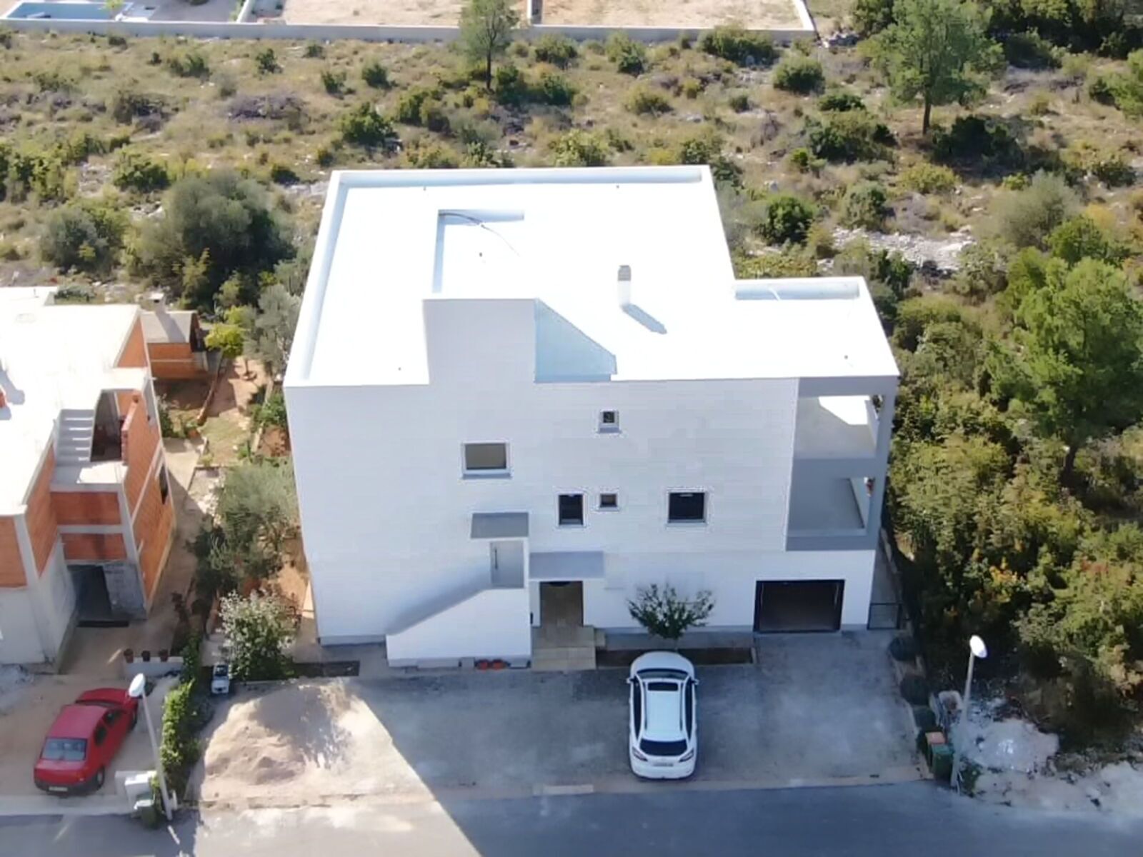 Un bâtiment moderne à deux étages, doté d’un toit plat et d’une entrée centrale.