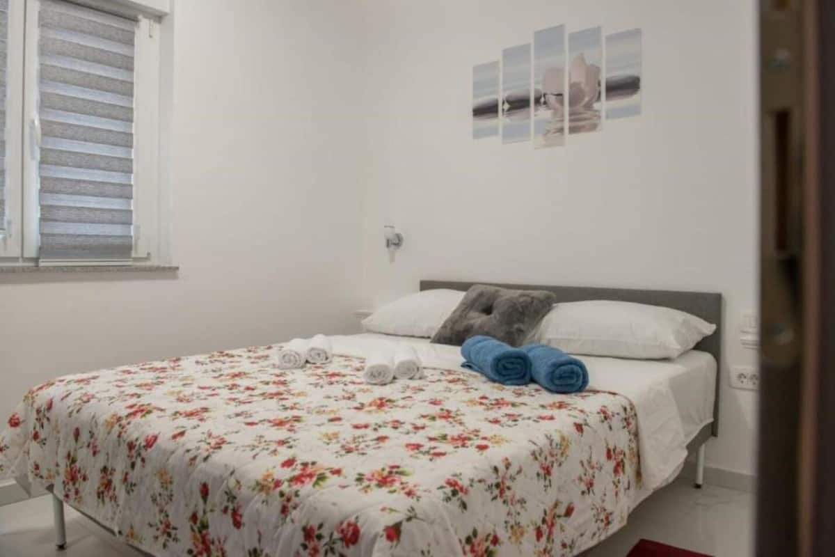 A bedroom with a bed, pillows, and a wall art piece.