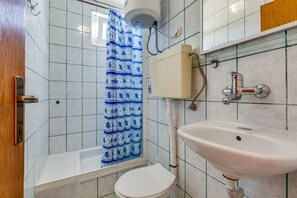 A bathroom with a bathtub, toilet, and sink. - Apartments Tanja (Pakostane)