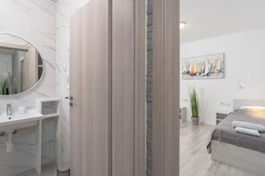 A modern bathroom with a marble sink, wooden paneling, and a large mirror. - Apartment Juli (Vir)