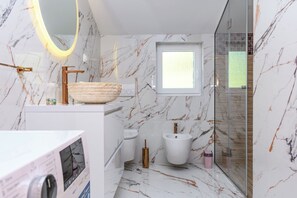 A modern bathroom with a marble floor, a vessel sink, a bidet, and a glass-enclosed shower. - Apartment Vidas (Rab)