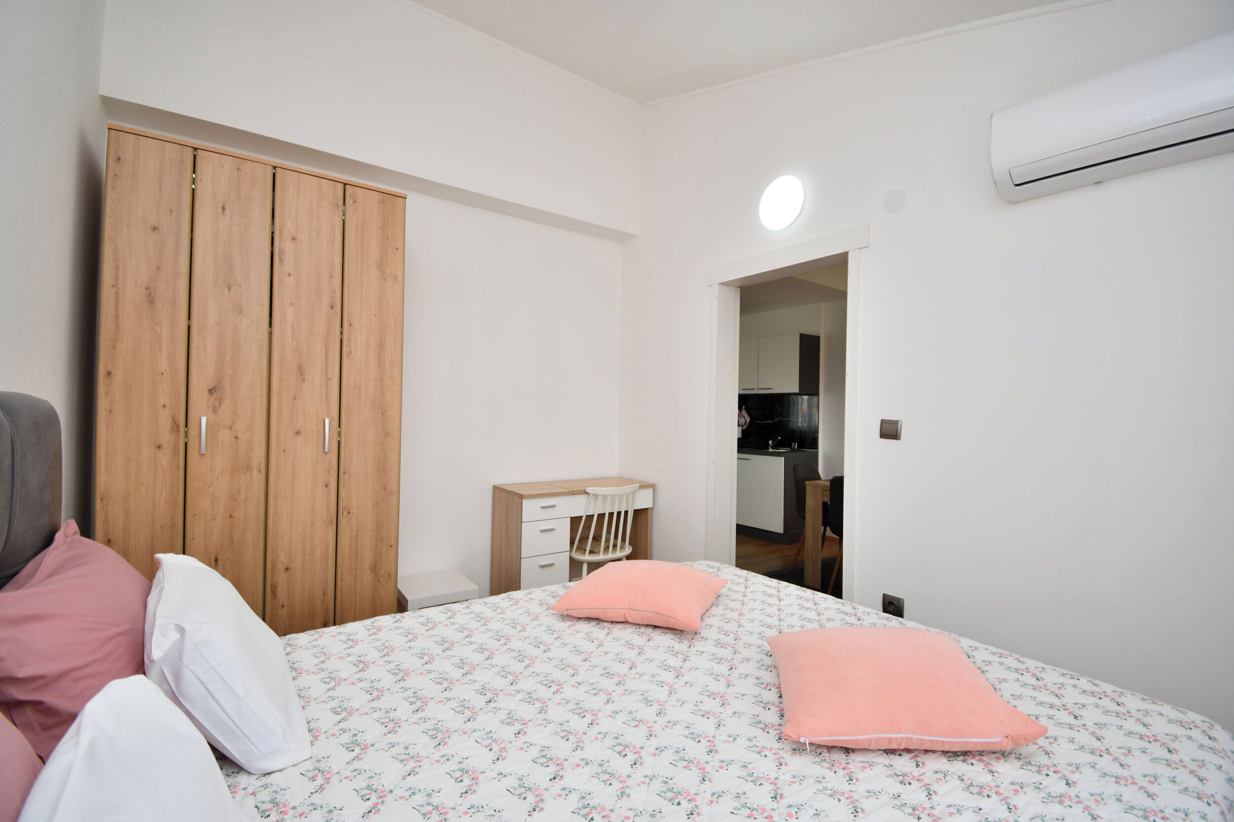 Une chambre comprenant un lit, une armoire, un bureau et un appareil de climatisation.