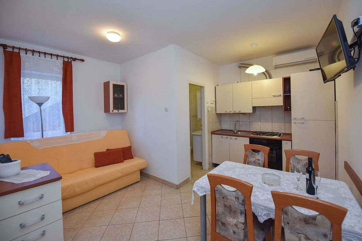 A compact living space with a sofa, dining table, and kitchenette.