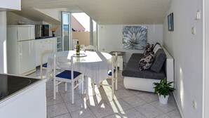 A compact living space with a dining area, kitchenette, and seating area. - Apartments Mandre Near sea (Kolan)