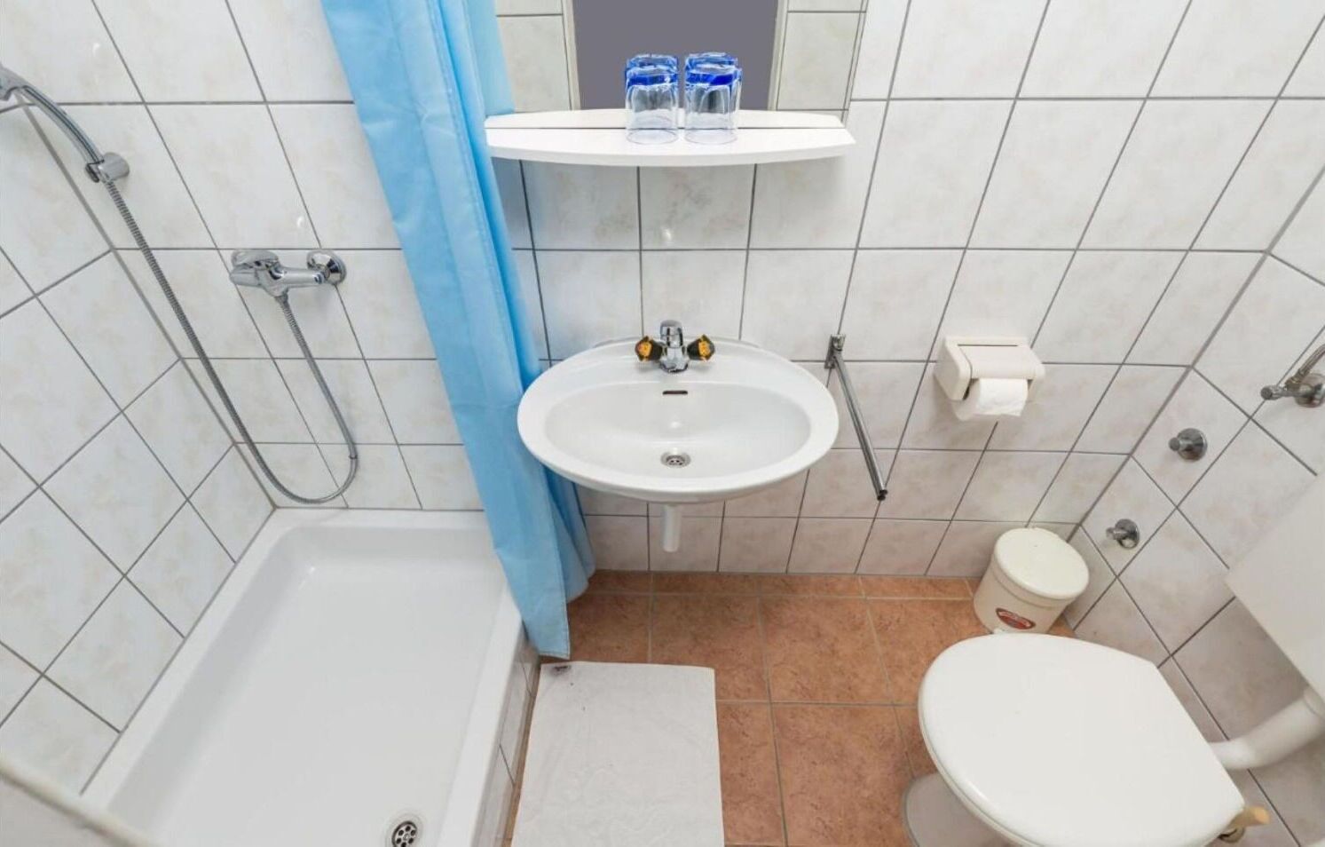 Een kleine badkamer met een bad, een wastafel en een toilet.