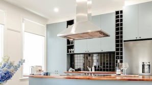 Una cocina moderna con una isla central, electrodomésticos de acero inoxidable y un ventanal grande.