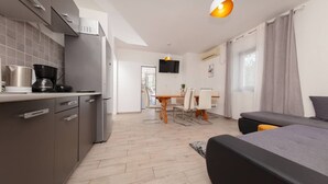 A modern apartment with a kitchenette, a dining area, and a bedroom. - House Berto (Medulin)