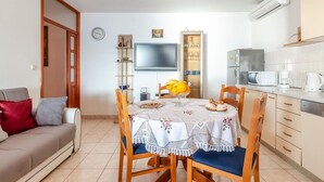 A compact living space with a dining area, kitchenette, and a sofa. - House Ivana (Blato)