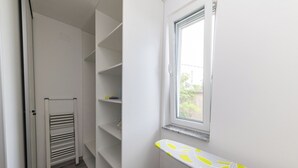 A narrow hallway with a built-in drying rack, a window with a view, and a small trash bin. - Apartment Ida (Crikvenica)